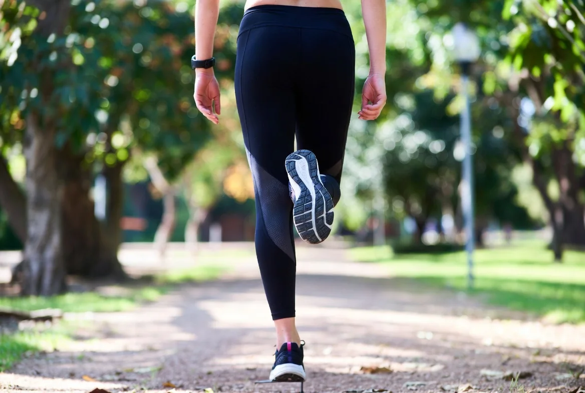 persona caminando en parque para prevenir piernas cansadas