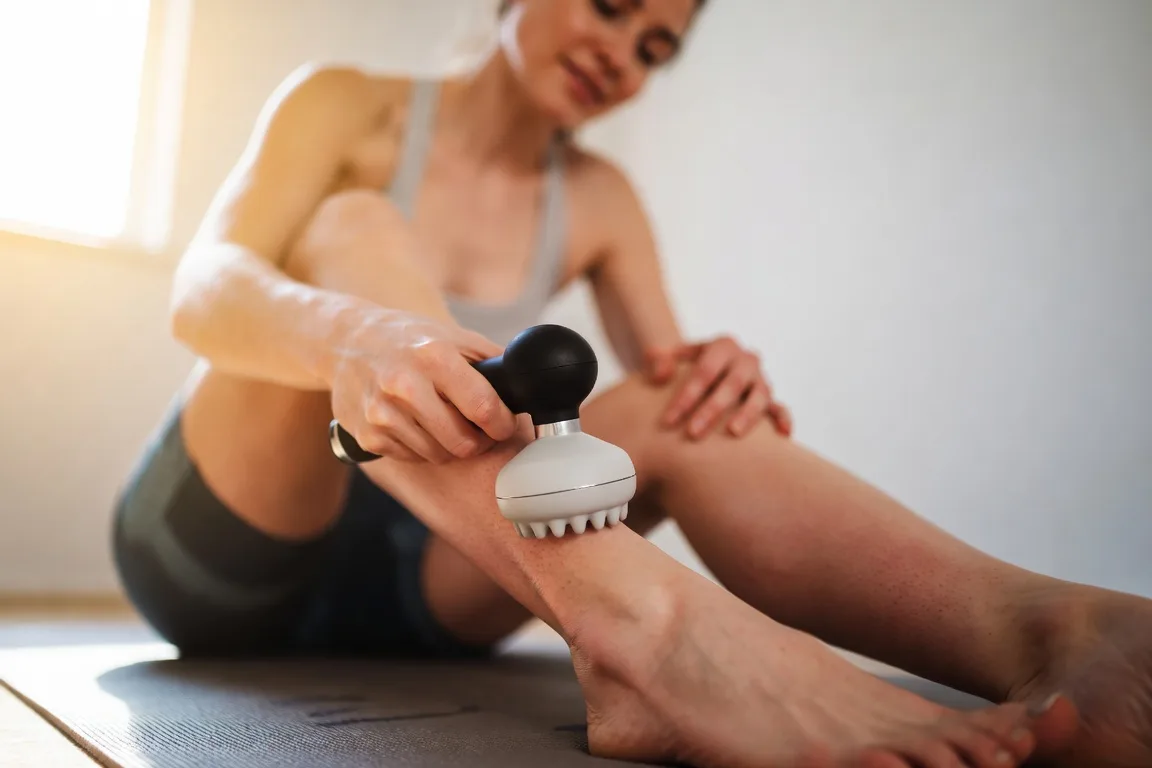 mujer usando masajeador muscular pantorrilla alivio dolor post ejercicio
