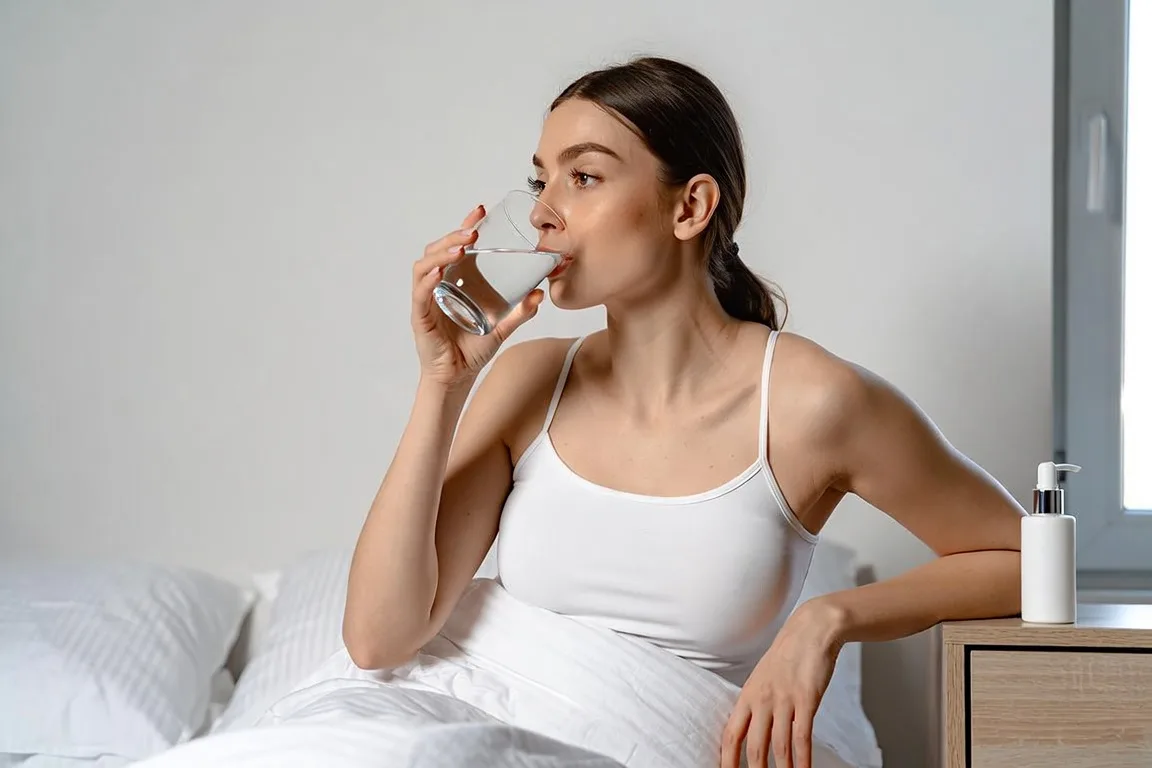 mujer bebiendo agua crema hidratante prevencion piel seca